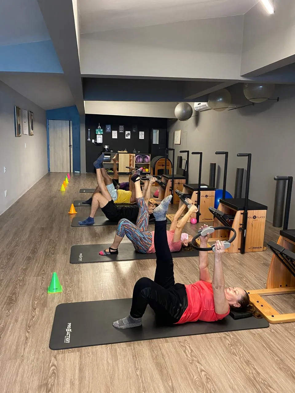 Aula em grupo no studio, com alunas no mat